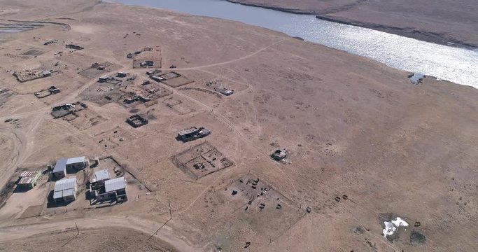 Livestock corrals on the outskirts of arid township by a river in dry land