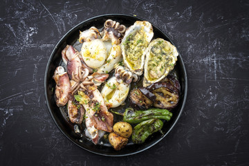 Traditional barbecue seafood platter with herb as top view on a plate with copy space
