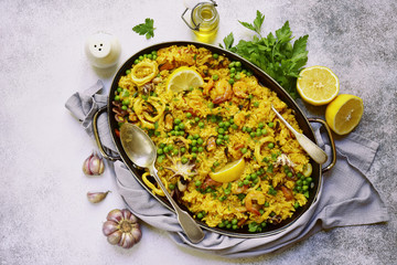 Classic valencian paella from rice with seafood and green pea - traditional dish of spanish cuisine.Top view. © lilechka75