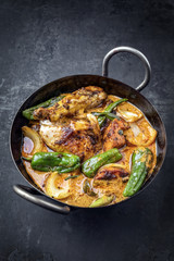 Traditional Thai kaeng massaman coconut chicken curry with jalapeno, poblano chili and sweet potatoes as closeup in a traditional bowl