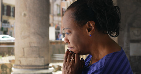 An elderly black woman prays inside the Pantheon in Rome