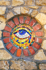 Mosaic Eye of Horus on stone wall.