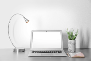 Laptop with blank screen on office table. Mock up for design