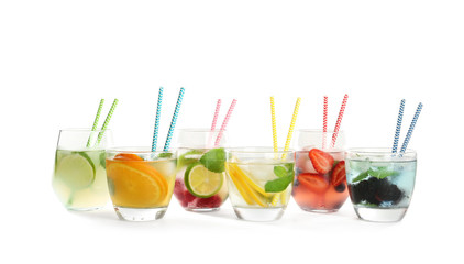 Glasses with tasty lemonades on white background