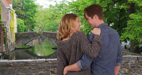 Rear view of young married couple looking out at canal smiling