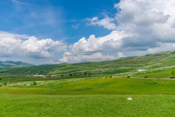Naklejka premium The picturesque village is among the meadows on the high mountains.