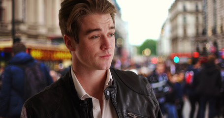 Handsome young man waiting for someone on busy London street