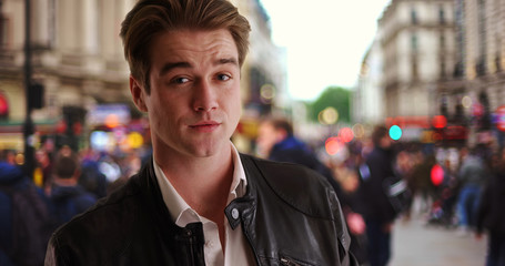 Handsome young man waiting for someone on busy London street