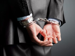 Cropped image of male hands in handcuffs
