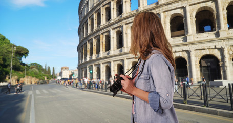 Rear view of travel photographer taking picture of the Colosseum