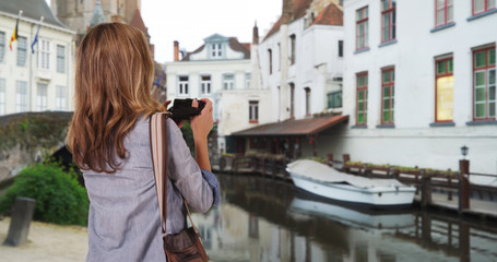 Obraz na płótnie Canvas Portrait of woman tourist with her camera in Bruges