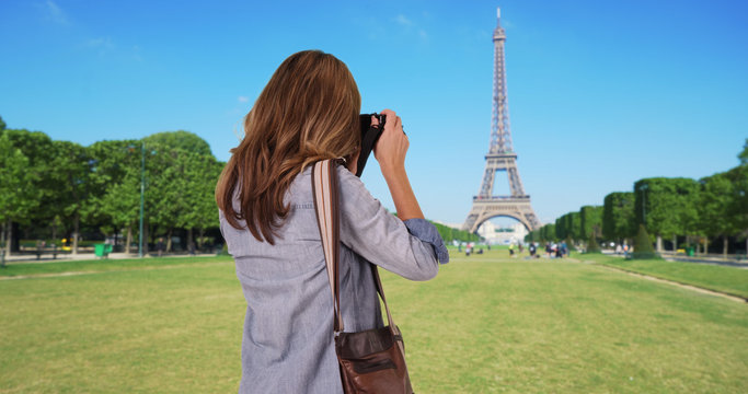 Rear view of travel photographer taking picture of the Eiffel Tower