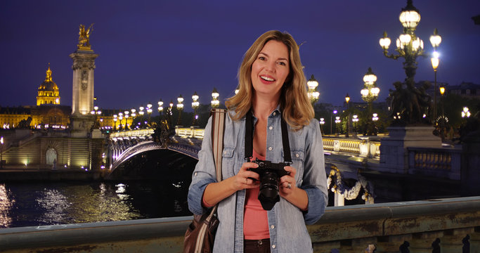 Travel photographer with her camera on gorgeous night in Paris