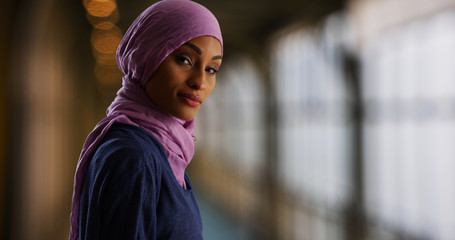 An attractive young Muslim woman turns to smile at camera