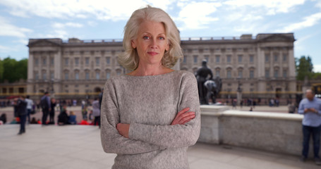 Confident woman tourist standing with arms crossed in London while on vacation