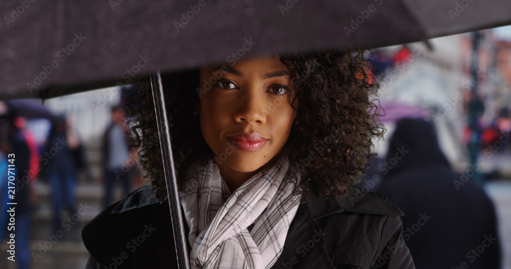 Wall mural African American tourist woman in Venice standing under umbrella on rainy day - Wall murals