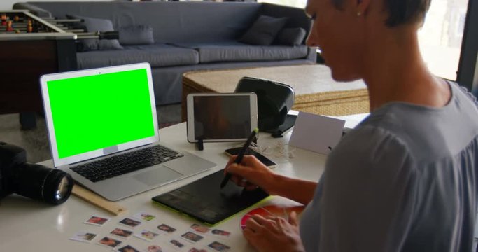 Female graphic designer using graphics tablet at desk 4k