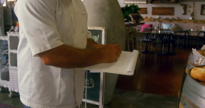 Chef maintaining records in the notepad 4k