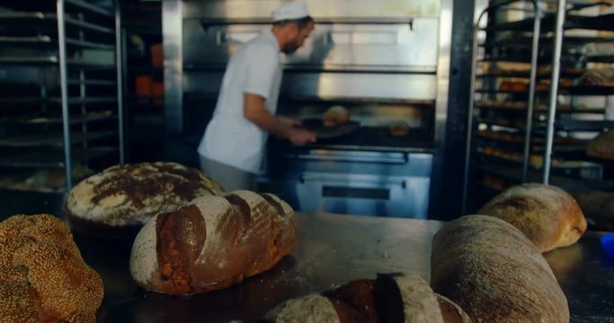 Male chef removing bread from the oven 4k