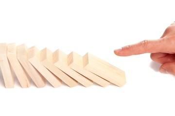 Male hand ready to push domino