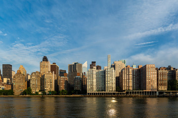 Fototapeta na wymiar New York City / USA - JUL 31 2018: Midtown Manhattan buildings, skyscrapers and apartments view from Roosevelt Island in the early morning
