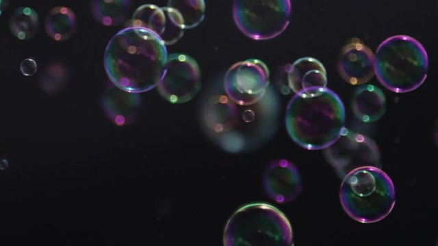 Slow motion bubbles in nature background abstract crisp clear soapy blown spheres