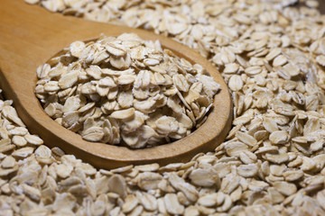Obraz na płótnie Canvas large flakes and whole oats in wooden spoon