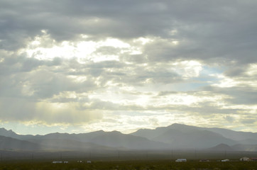 monsoon rain clouds over mountain range edging dry Mojave Desert valley landscape in Nevada, USA