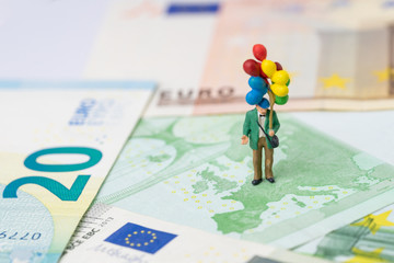 Europe, Brexit financial or economy concept, miniature people happy old man politician holding balloons on European map on Euro banknote