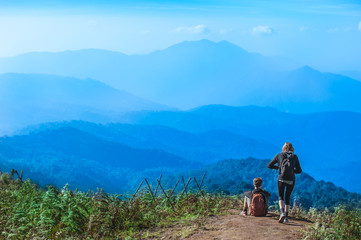 Fototapeta premium Couple Travelers Man and Woman with backpack sitting relaxed on mountain