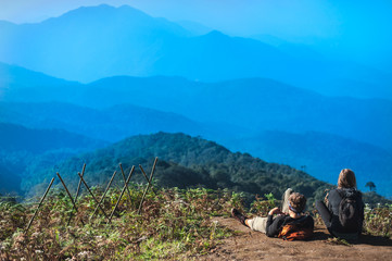 Fototapeta premium Couple Travelers Man and Woman with backpack sitting relaxed on mountain