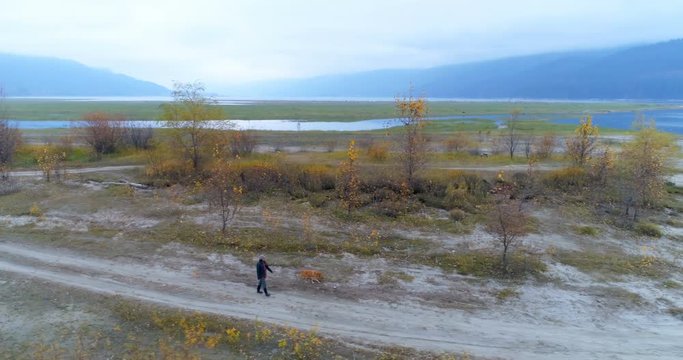 Man walking with his dog on dirt track 4k