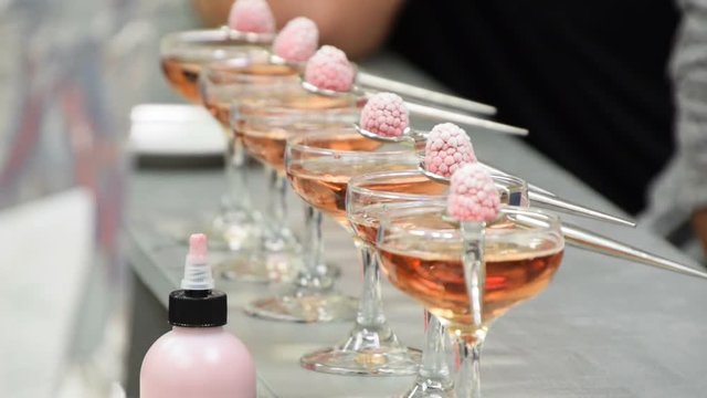 Several orange drinks are served in glasses with raspberries as a garnish
