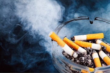 Ashtray and smoked cigarettes on backgrouund