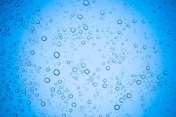 Rain droplets on blue glass background, Water drops on glass.