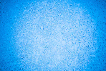Naklejka na ściany i meble Rain droplets on blue glass background, Water drops on glass.
