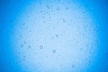 Rain droplets on blue glass background, Water drops on glass.