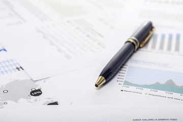 pen with financial paper.
