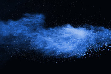 Blue powder explosion on black background. Colored cloud. Colorful dust explode. Paint Holi.
