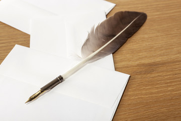feather pen with paper on the wood table