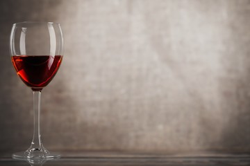 Red wine glass on wooden desk at