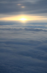 Fototapeta na wymiar Sunset Over Sea of Clouds and Horizon line from a Plane.