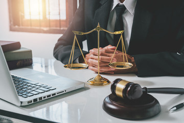 justice and law concept.Male lawyer in the office with brass scale and gavel and laptop and legal...