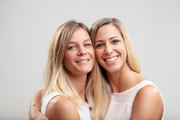 Two young blond women in a close embrace