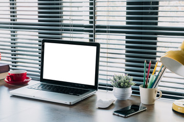Mock up laptop, office supplies on stylish minimal desk.Laptop computer with blank screen for product display.