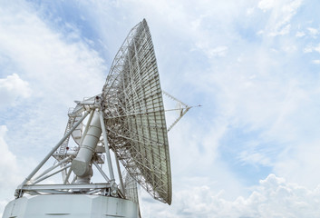 Big large white satellite dish turn up skyward on blue sky in earth communication antenna system...