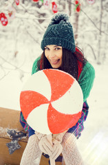 brunette girl in a green hat and in a costume of flowers traditional to the elves Santa's helpers...
