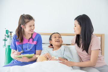 Young asian girl patient and mother smiling while doctor come to visit