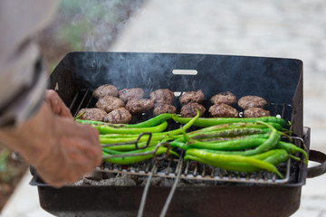 Meatballs and long green peppers on the Grill