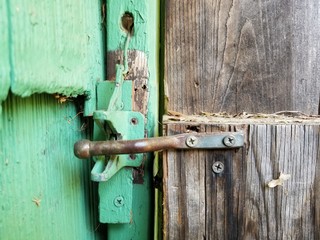 Unlocked gate to the backyard with green paint on the house